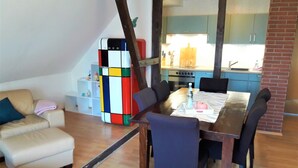 A dining area with a wooden table, chairs, and a colorful cube structure.
