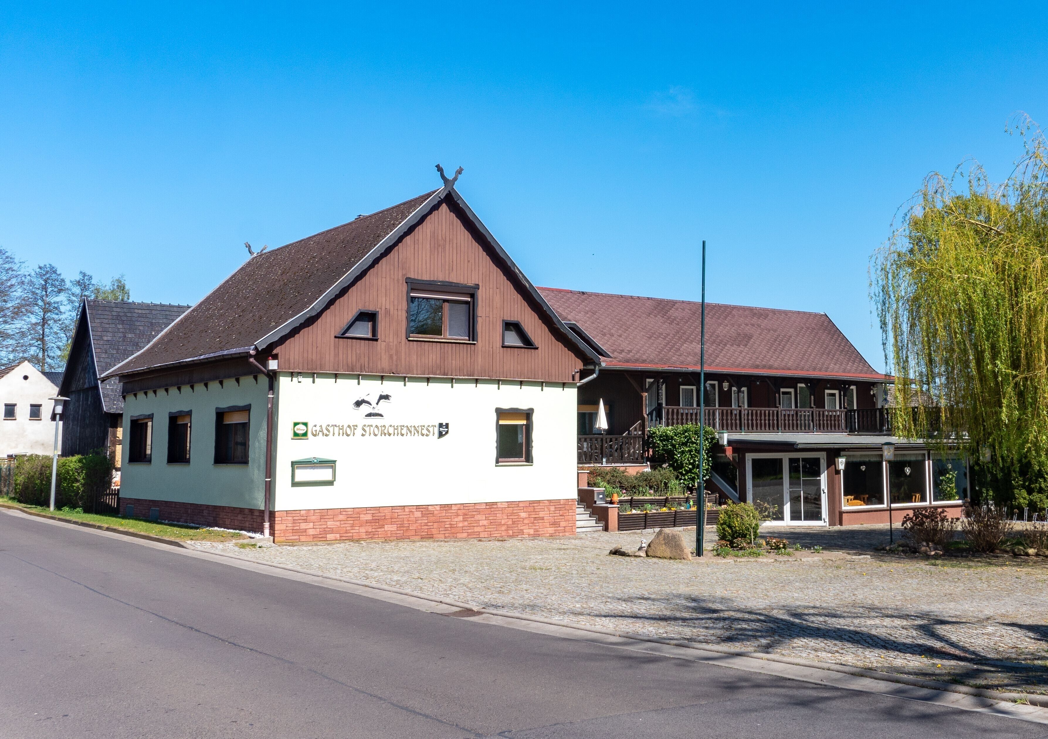 Ein Gebäude mit einem Schild, auf dem 'GASTHOF STORCHENNEST' steht.