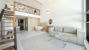 A modern interior with a staircase, a living area with a glass coffee table, a sofa, and a bathroom with a freestanding bathtub. - Taean Anmyeondo Bohemia Village Pension (Taean)