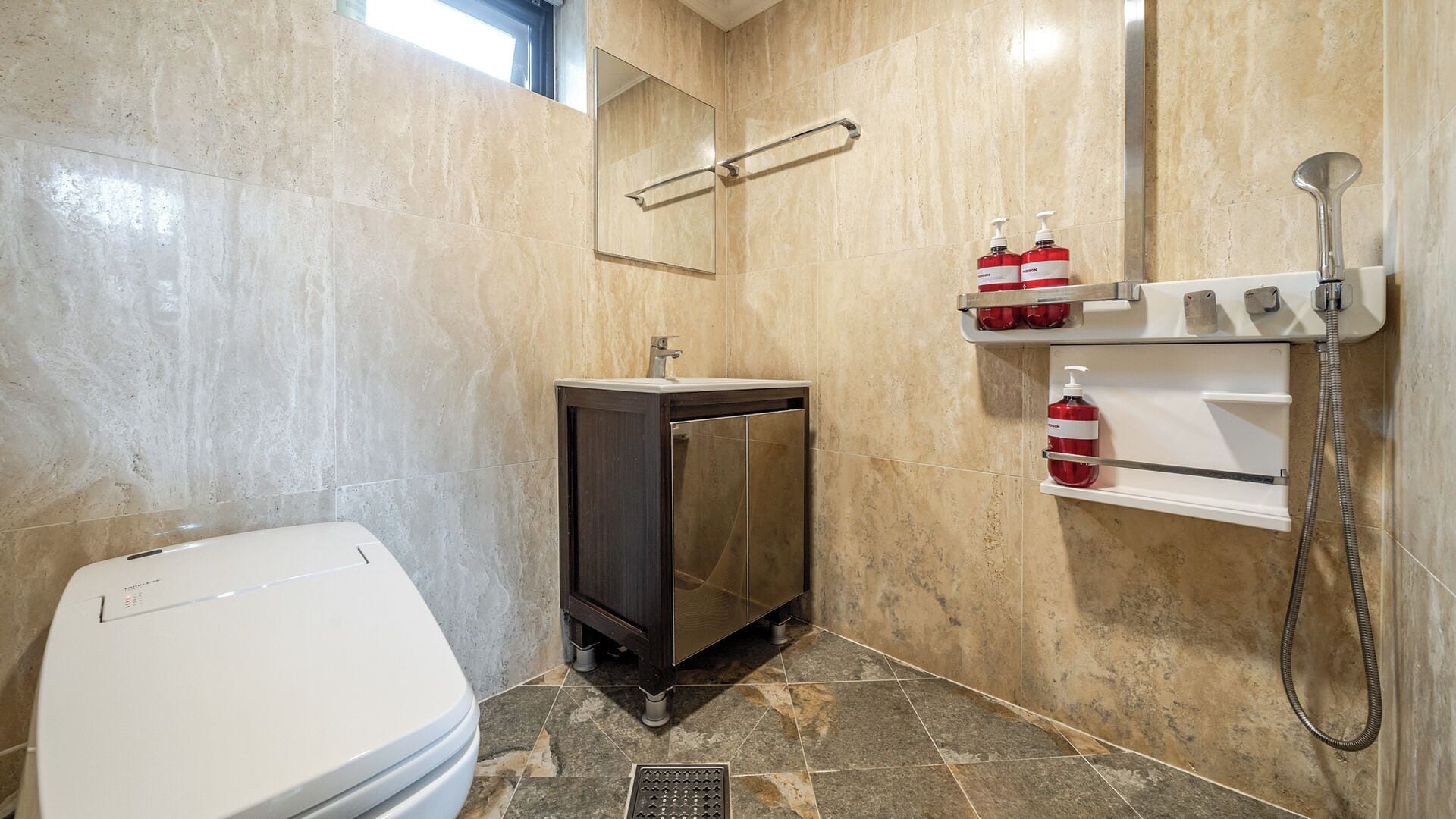 A bathroom with a toilet, a cabinet, a mirror, and a shower.