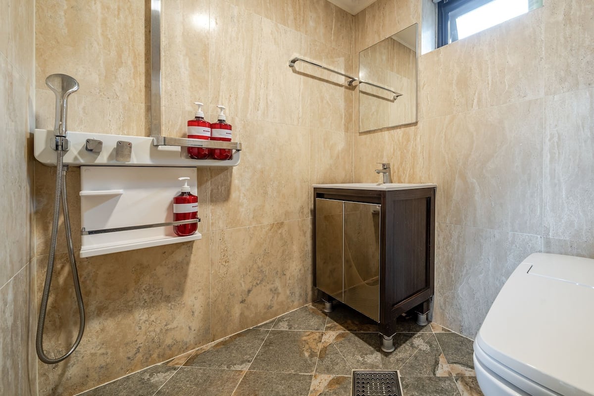 A bathroom with a shower, a sink, and a toilet.