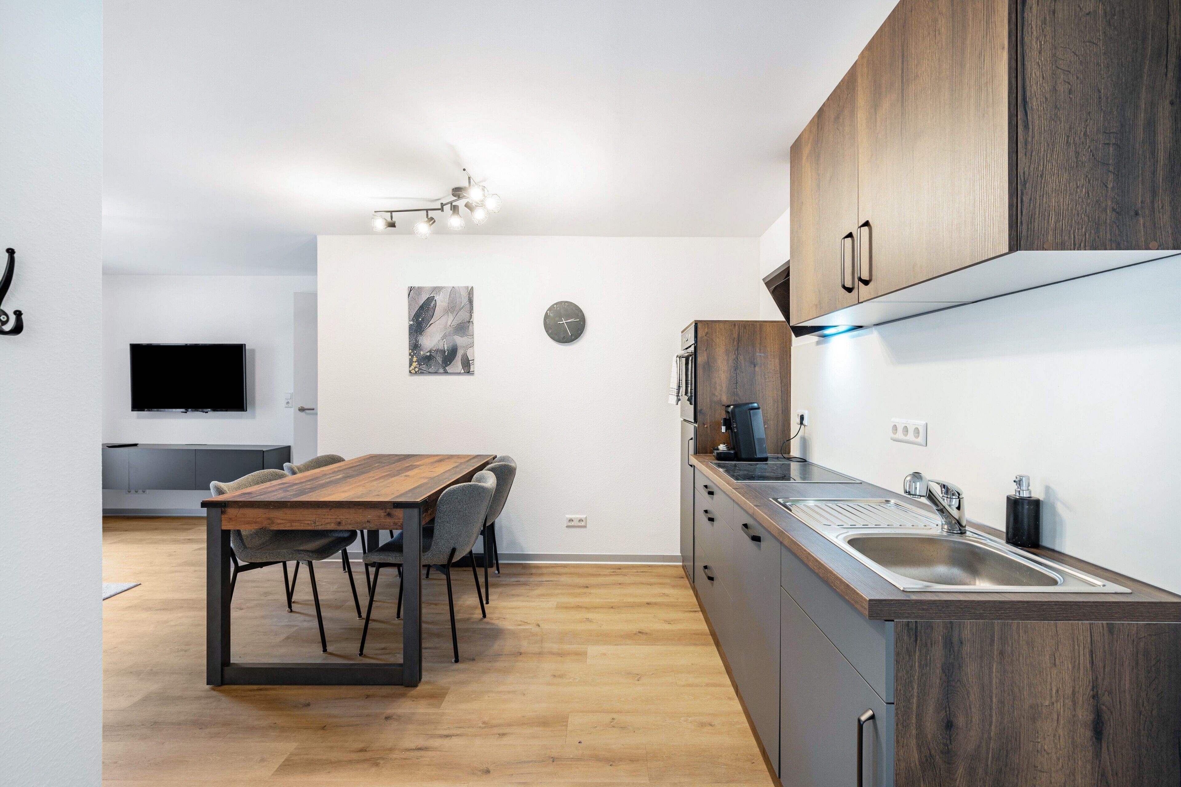 A modern kitchen with wooden cabinets, a built-in oven, and a large window.