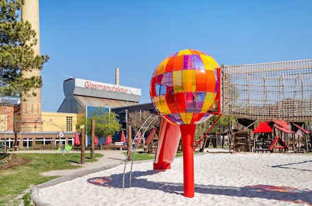 A colorful hot air balloon sculpture in a park area with a building labeled 'Glasmannfabrik' in the background.. Holiday Home 'Am Park' with Private Terrace, Private Garden and Wi-Fi