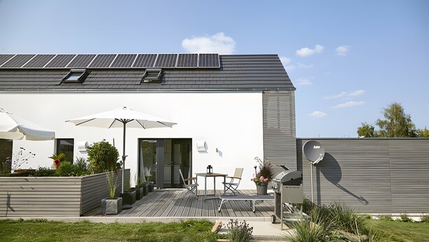 A modern house with solar panels, a patio with outdoor furniture, and a satellite dish. - Studio 'Charmingsuite' with Private Terrace, Shared Garden and Wi-Fi (Bad Teinach-Zavelstein)