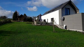A modern house with a sloped roof, a satellite dish, and a well-maintained lawn. - Studio 'Charmingsuite' with Private Terrace, Shared Garden and Wi-Fi (Bad Teinach-Zavelstein)