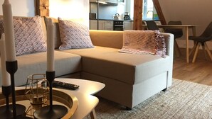 Een gezellige woonkamer met een bank, een bijzettafeltje en een afstandsbediening.