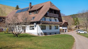 A two-story house with a sloped roof, solar panels, and a balcony. - Apartment 'Armbruster' with Shared Terrace, Shared Garden and Wi-Fi (Sankt Georgen)
