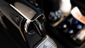 A close-up of a car's interior, focusing on the gear shift and control panel.
