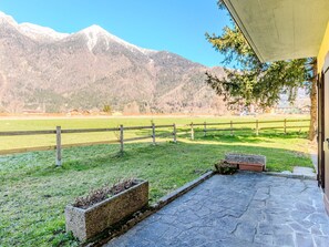 A stone patio with a view of a mountain range.