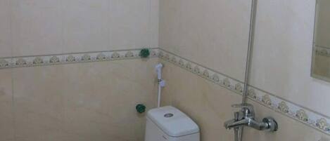 A bathroom with a toilet, a shower, and a sink.