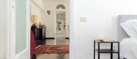 Une chambre à coucher avec un lit, une petite table et une bibliothèque en arrière-plan.