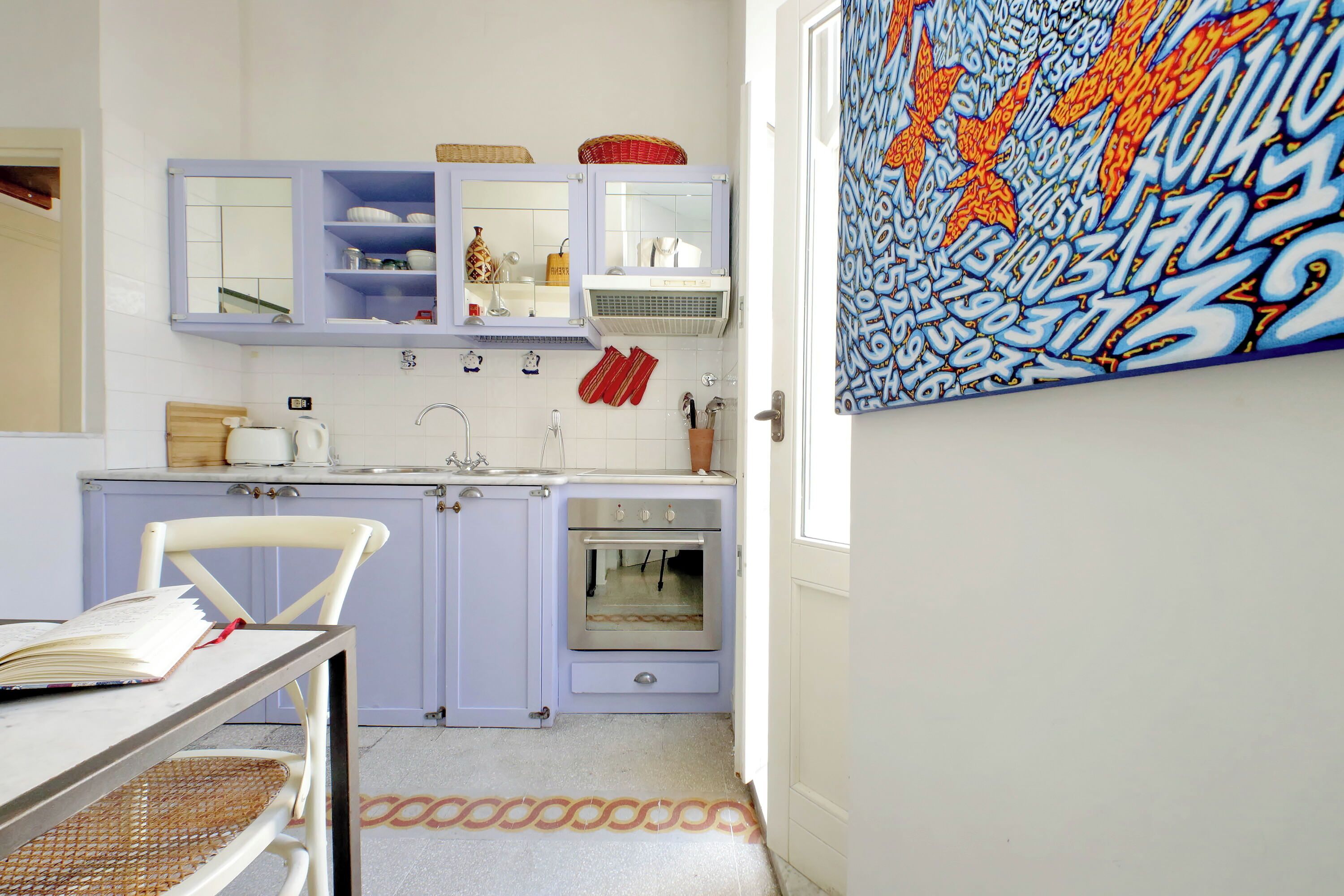 A kitchen with a vintage stove, a sink, and a cabinet with a mirror.