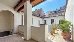 A courtyard with a brick floor, a wooden pergola, and a potted plant. - Ottavia Terrace (Rome)