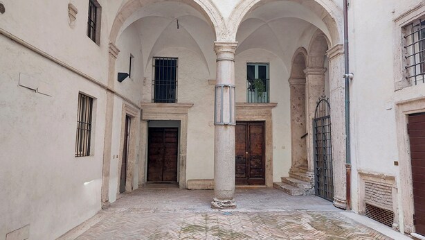 An interior courtyard with arched doorways, a central column, and a tiled floor. - Ottavia Terrace (Rome)