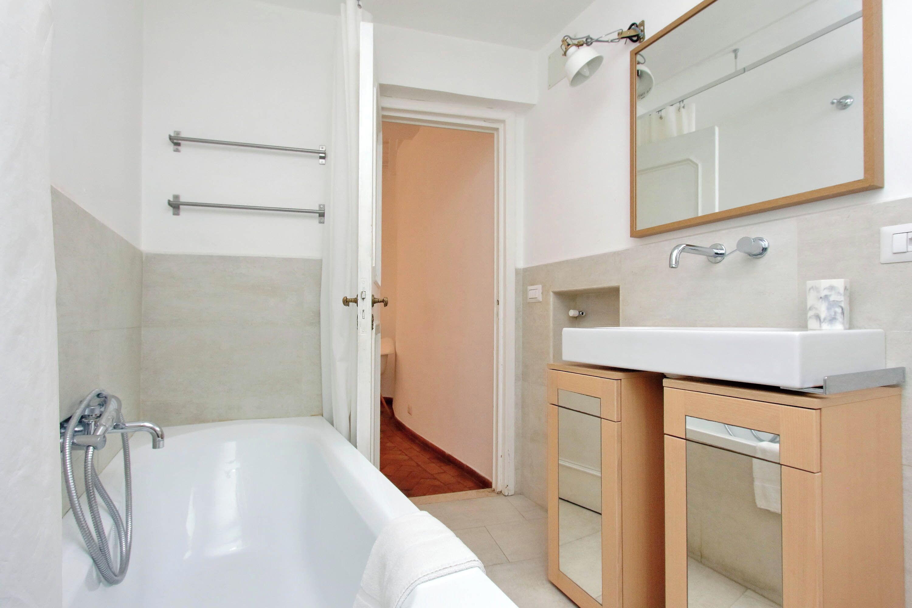 A modern bathroom with a bathtub, a sink, and a mirror.