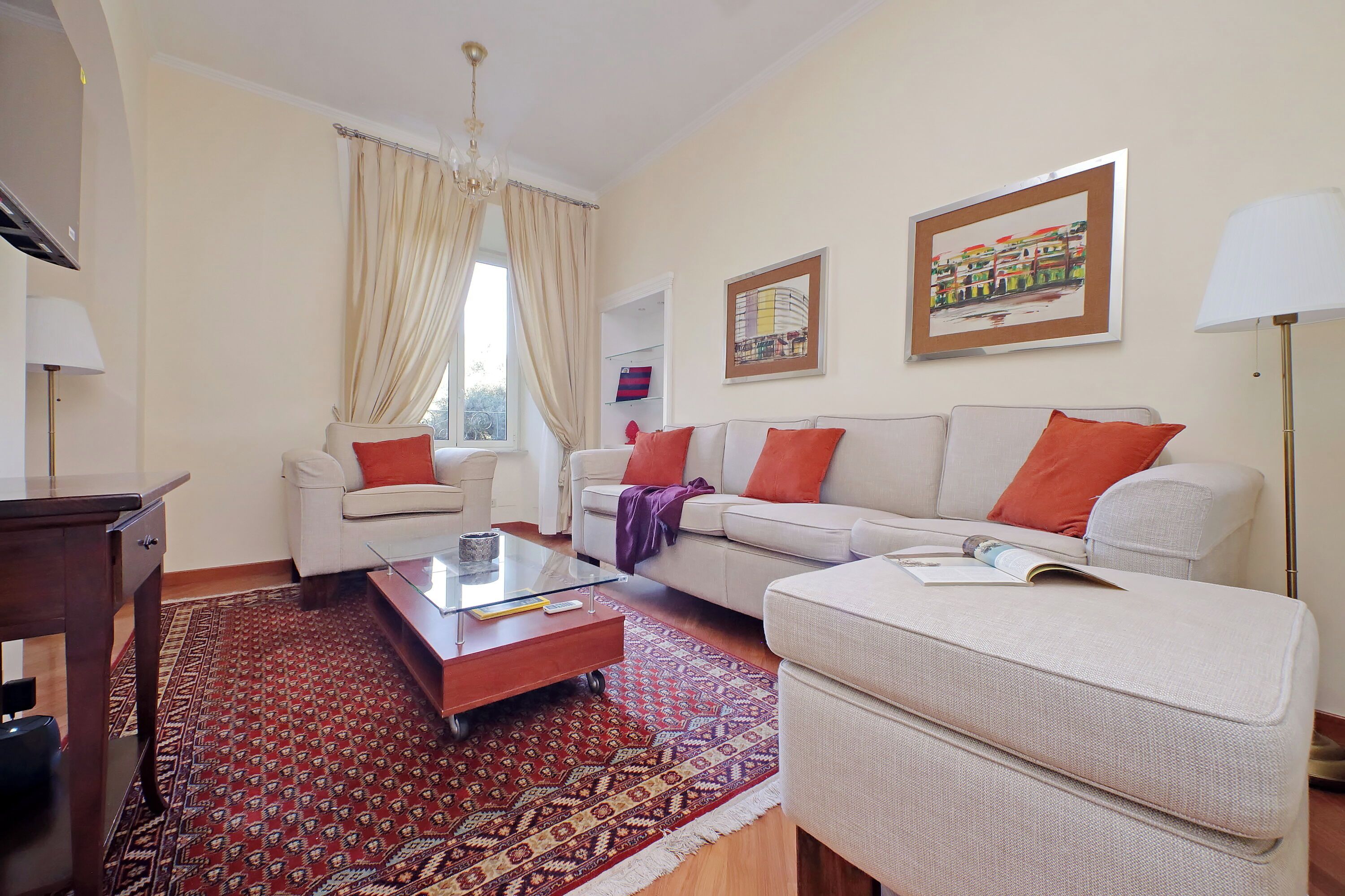 A living room with a sofa, armchair, coffee table, and a patterned rug.