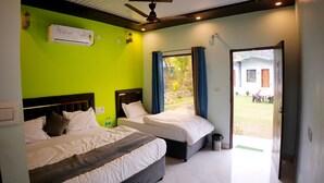 A hotel room with two beds, a ceiling fan, an air conditioning unit, and a view of the outside.