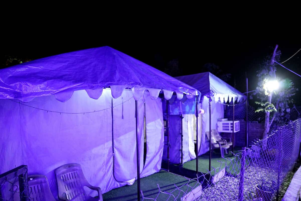 A tented area with a covered seating area and a fenced perimeter.