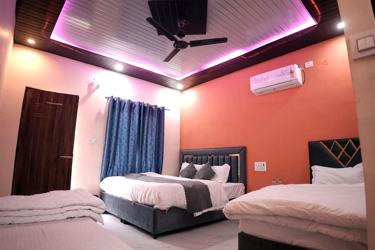 A bedroom with a bed, a ceiling fan, and an air conditioning unit.