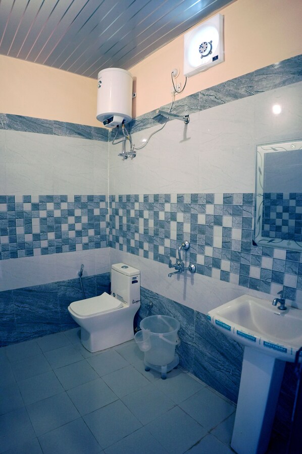 A bathroom with a toilet, sink, and shower.