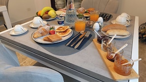 A breakfast table set with croissants, toast, fruit, juice, and coffee. - La Residenza del Barone (Camerota)