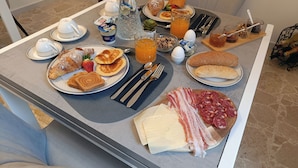 A breakfast table with croissants, toast, strawberries, pancakes, and various spreads. - La Residenza del Barone (Camerota)