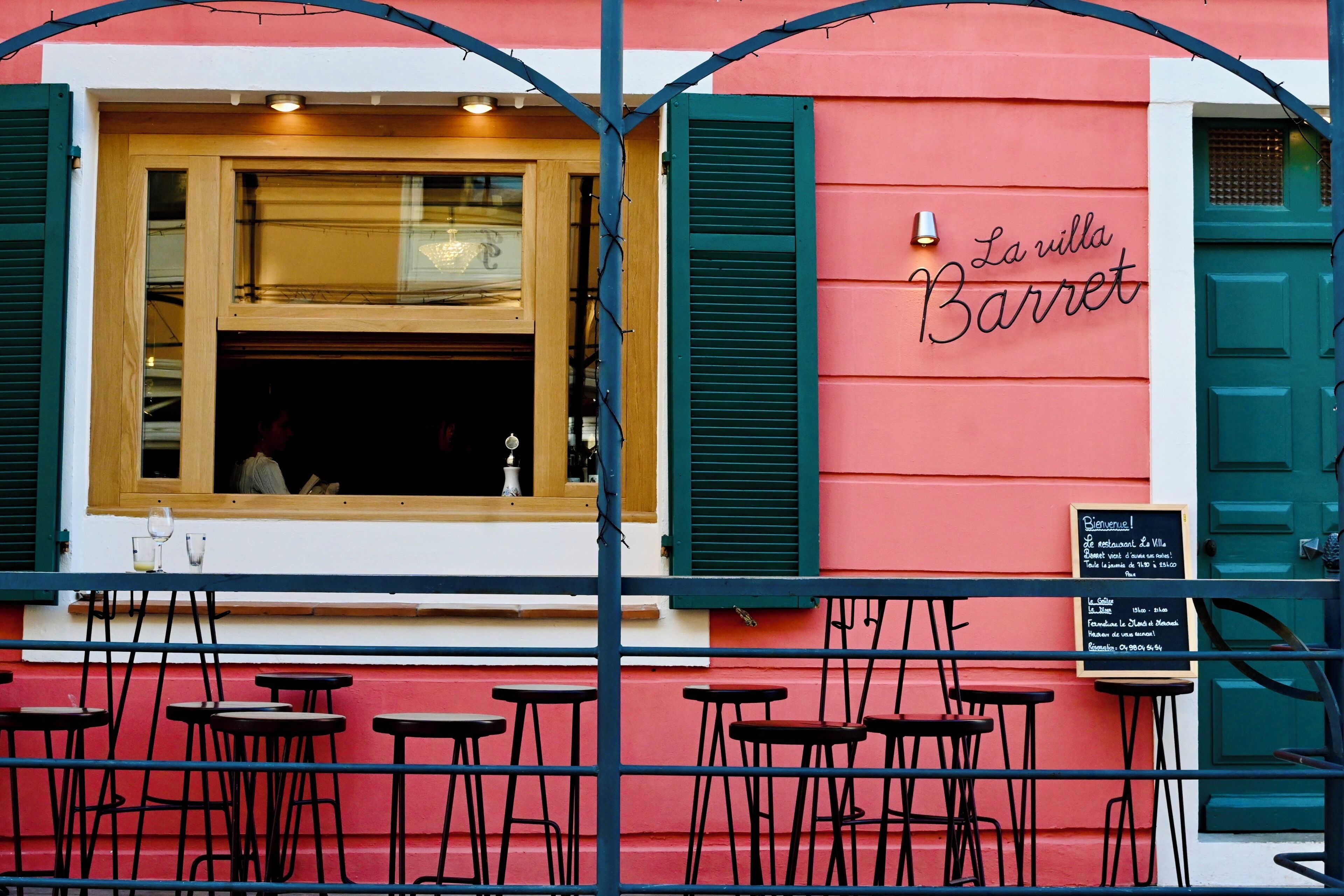 Un restaurante llamado "La villa Barret" con terraza y un marco de ventana de madera.