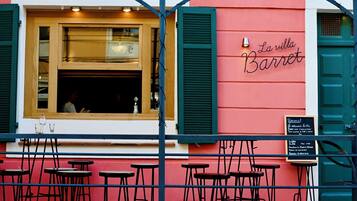 Un restaurante llamado "La villa Barret" con terraza y un marco de ventana de madera.