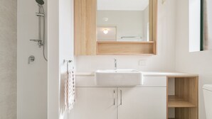 Une salle de bain moderne avec une douche, un lavabo et un miroir.