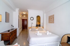 Habitación de hotel con una cama grande, un aparador de madera, un espejo y una obra de arte colgada en la pared.