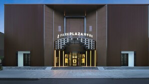 A modern building with a prominent entrance and illuminated signage.