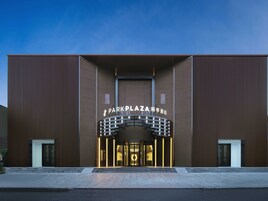 A modern building with a prominent entrance and illuminated signage.
