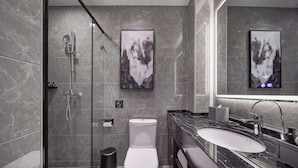 Un baño moderno con ducha, inodoro y lavamanos.
