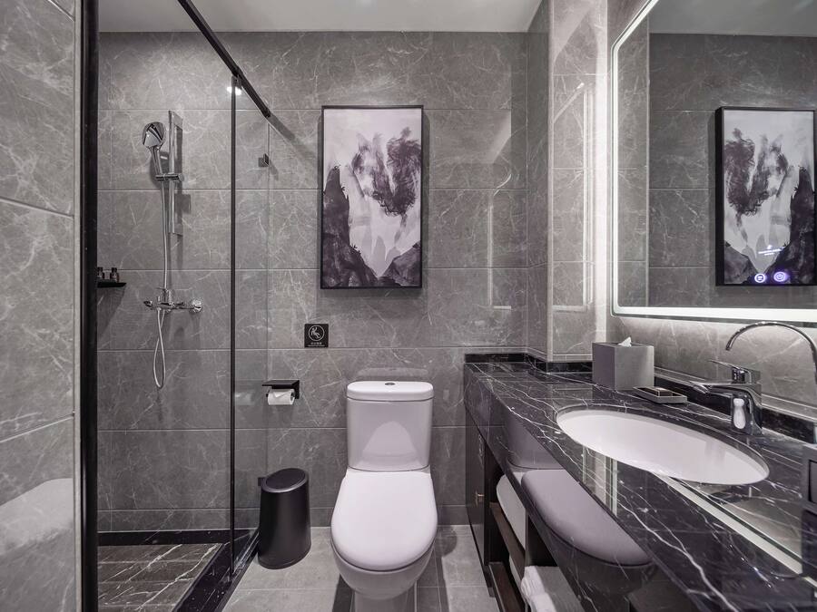A modern bathroom with a shower, toilet, and sink.