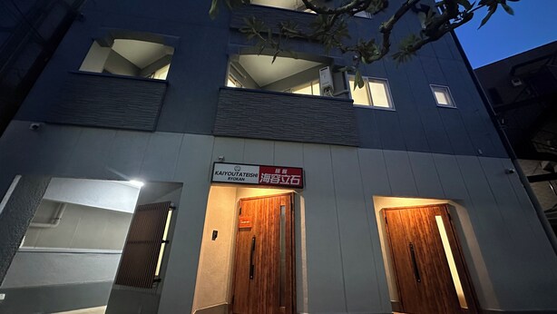 A multi-story building with two wooden doors and a sign indicating a restaurant. - KAIYOUTATEISHI (Tokyo)