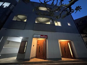 A multi-story building with two wooden doors and a sign indicating a restaurant. - KAIYOUTATEISHI (Tokyo)
