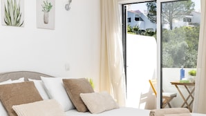 A bedroom with a bed, pillows, and a view of the outside. - Family-Friendly Apartment in Carvoeiro (Carvoeiro)