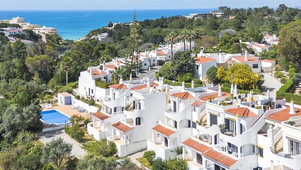 A coastal residential area with white buildings, red-tiled roofs, and a swimming pool. - Family-Friendly Apartment in Carvoeiro (Carvoeiro)