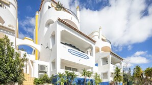 A modern building with multiple balconies, a blue and white color scheme, and a clear sky. - Family-Friendly Apartment in Carvoeiro (Carvoeiro)