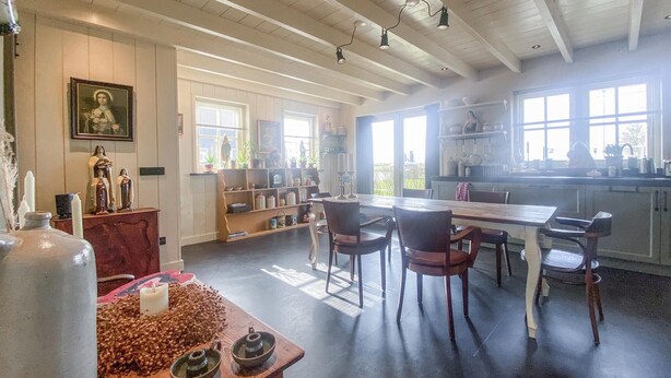 A spacious kitchen with a dining area, wooden ceiling beams, and large windows. - Nice home in Westerland (Westerland)