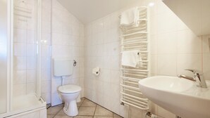 A bathroom with a toilet, a sink, and a towel rack.
