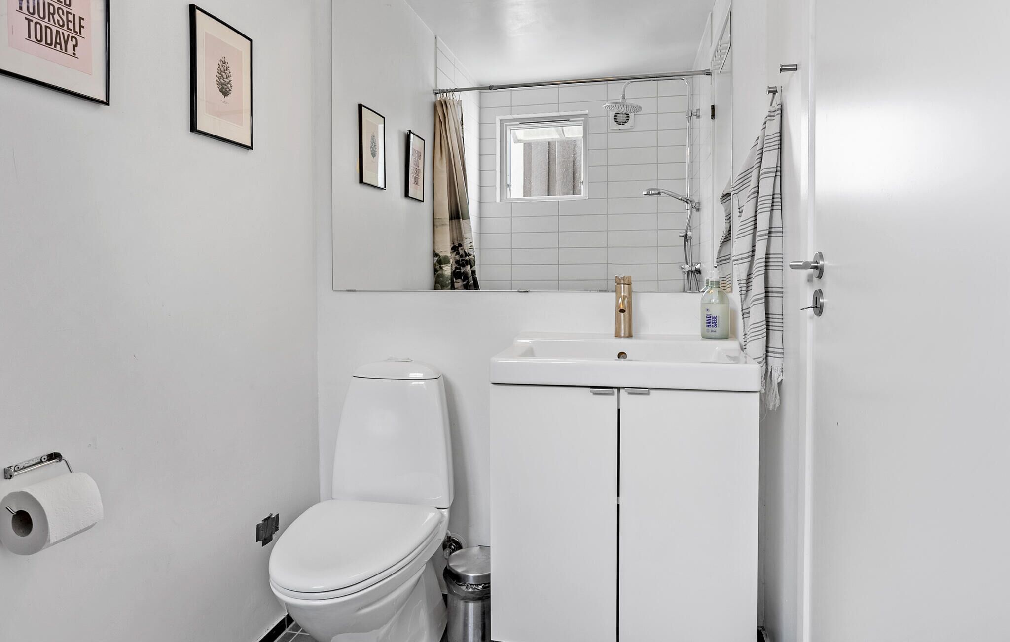 Une salle de bain moderne équipée de toilettes, d’un lavabo et d’une douche.