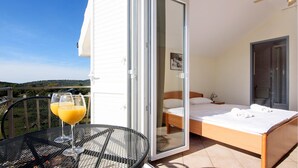 Un balcon avec une table et des chaises, un lit et une salle de bain.
