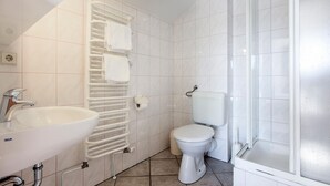 Une salle de bain avec un lavabo, des toilettes et un porte-serviettes.