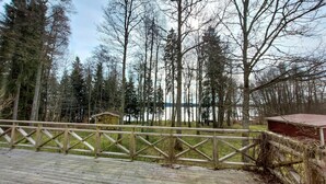 A wooden deck with a railing, overlooking a forested area and a body of water. - Amazing home in ör with WiFi (Ör)