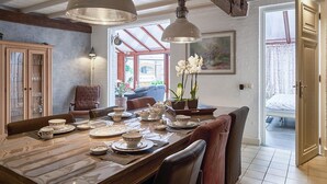 A dining area with a wooden table set for a meal, a chandelier, and a view of the outdoors. - Pet friendly home in Ospel with WiFi (Ospel)