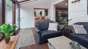 A modern living room with leather sofas, a wooden coffee table, and a large mirror. - Pet friendly home in Ospel with WiFi (Ospel)