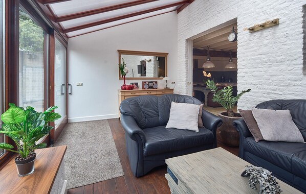 A modern living room with leather sofas, a wooden coffee table, and a large mirror. - Pet friendly home in Ospel with WiFi (Ospel)
