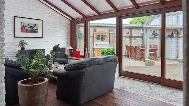 A modern living room with a large sliding glass door leading to an outdoor patio area. - Pet friendly home in Ospel with WiFi (Ospel)