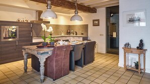 A modern kitchen with a central island, pendant lighting, and a dining area with chairs. - Pet friendly home in Ospel with WiFi (Ospel)
